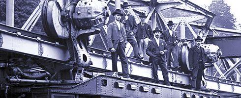Foto von Mitarbeitern der Baufirmen auf einem aufgehängten Wagenteil